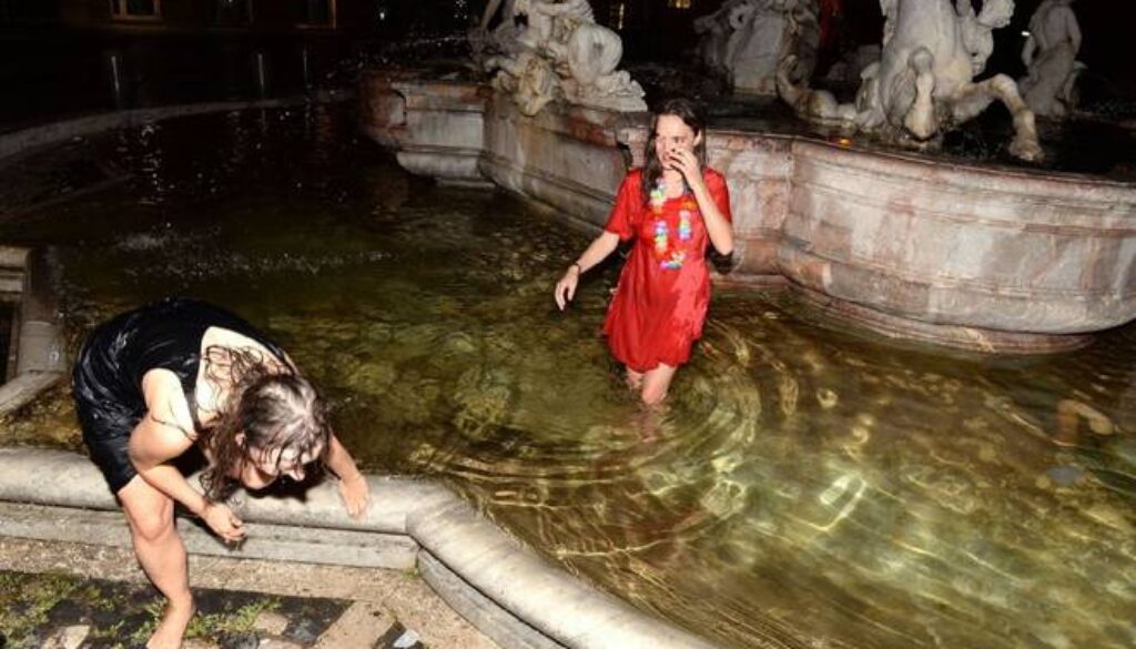 turiste fanno il bagno nella fontana del Nettuno