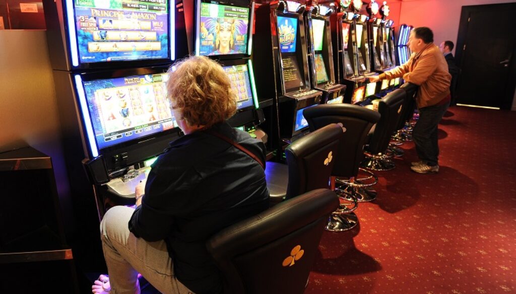 People stand in front of slot machines i