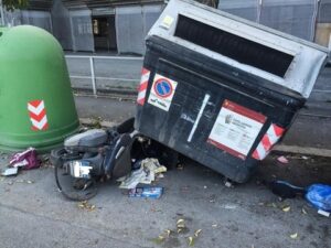 Cassonetto finisce sopra uno scooter