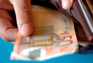 Close-up of a person's hand keeping euro banknotes in a wallet Close-up of a person's hand keeping euro banknotes in a wallet